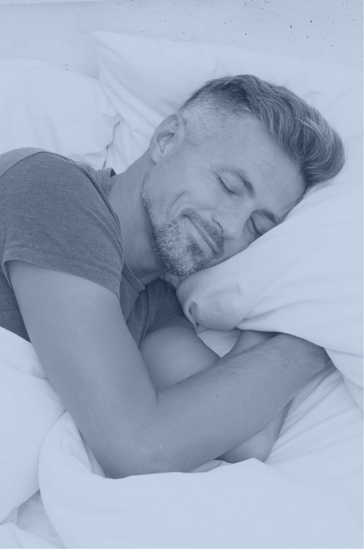 closeup of a handsome mature man sleeping peacefully in a bed with a white pillow