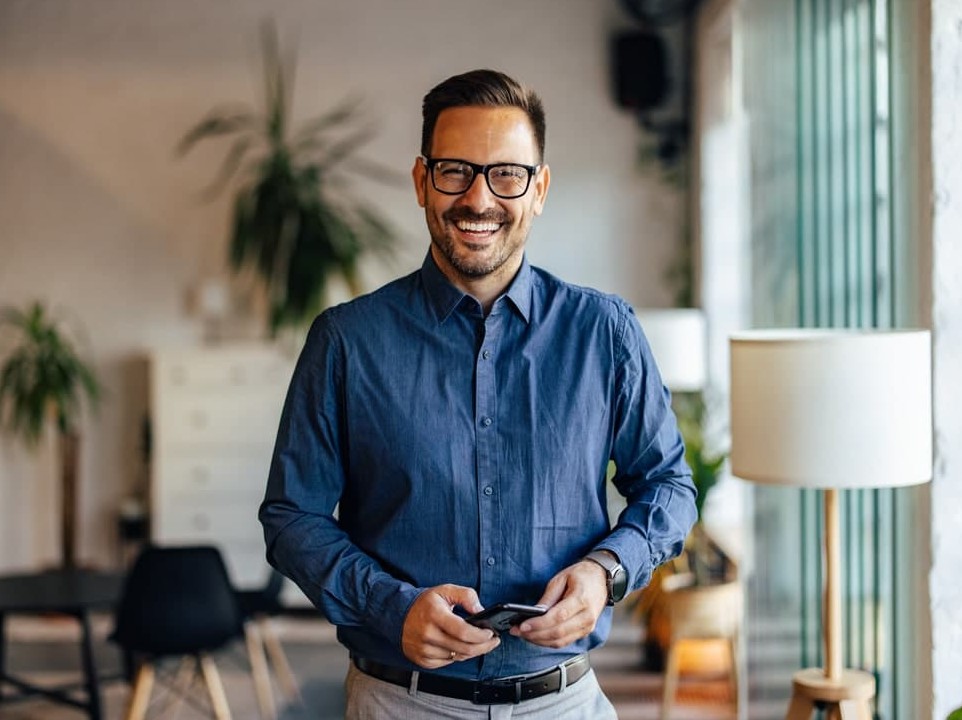 man in glasses and blue shirt smiling