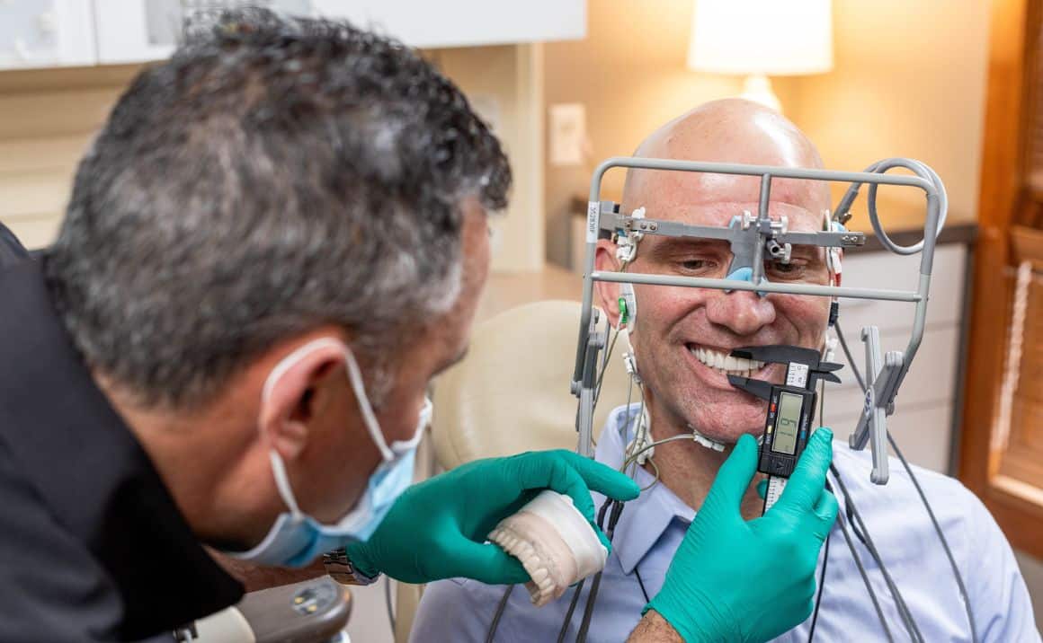 Dr. Haddad measuring a patient's jaw position during oral appliance fitting for sleep apnea treatment.