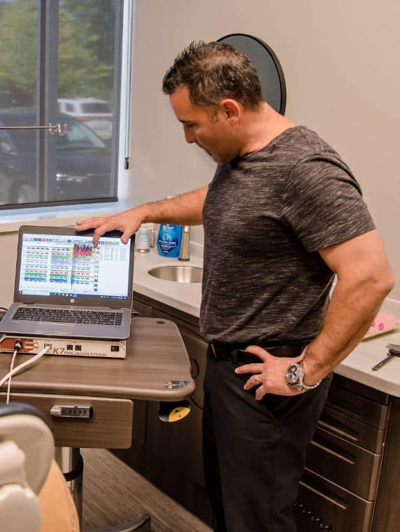 Service page image stack 4 Dr. Haddad reviewing computerized TMJ diagnostic data to guide personalized treatment planning.