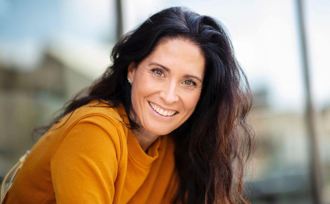 Service page content 11 Smiling woman outdoors, conveying confidence, well-being, and a positive treatment outcome.